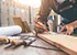 Carpenter working with equipment on wooden table in carpentry shop. woman works in a carpentry shop.