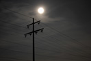 Stromleitungen vor dem Mond